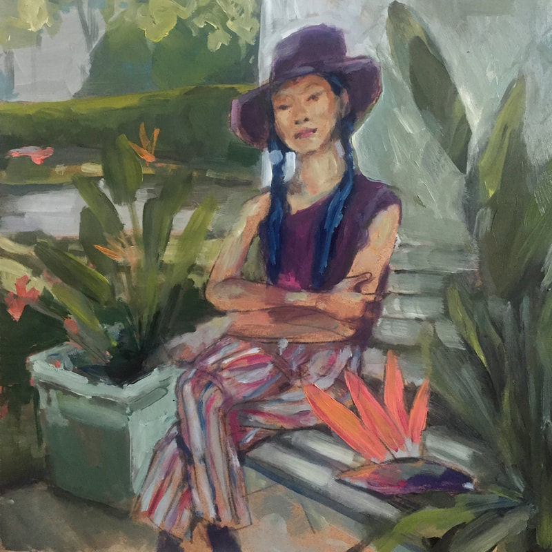 Asian woman wearing purple hat and top and striped pants seated on a bench in a garden surrounded by lush greenery and bird of paradise plants.
