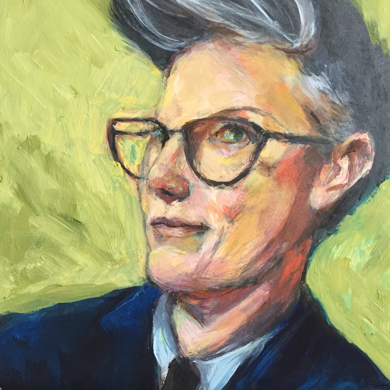 Hannah Gadsby wearing blue suit and tie, smirking. Background is vibrant yellow green.